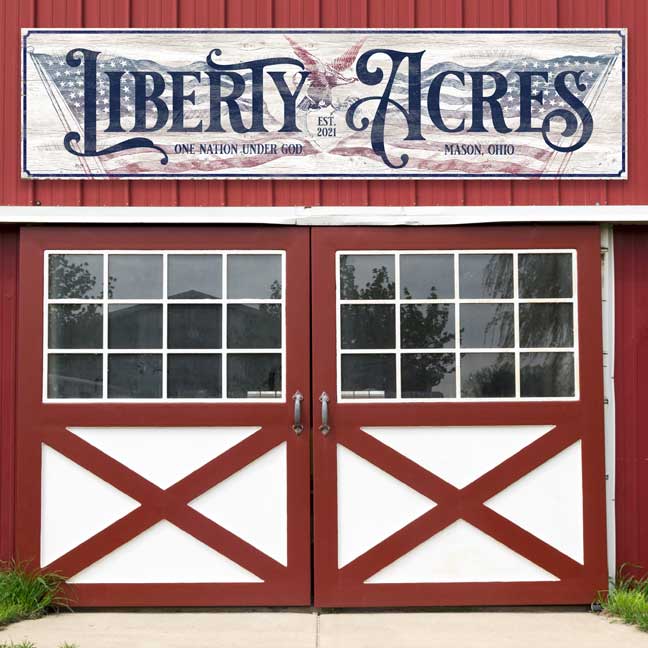 Large barn sign in red, white and blue displaying the American Flag with and eagle.