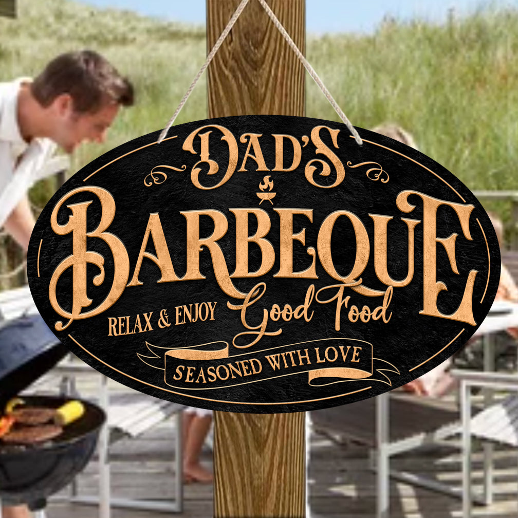 Oval Sign with Black background with gold lettering "Dad's Barbeque"  relax and enjoy, good food, seasoned with love.