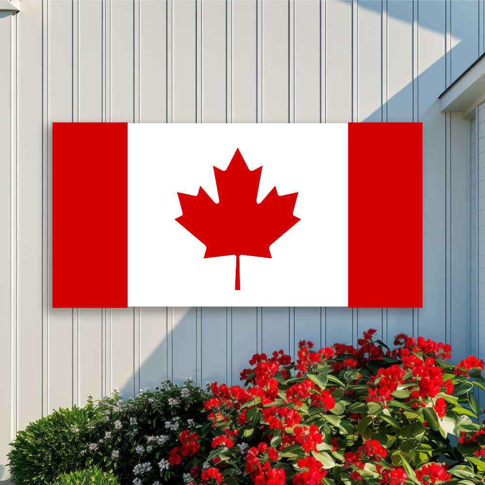 Large canadian flags made of metal on a white barn wall.