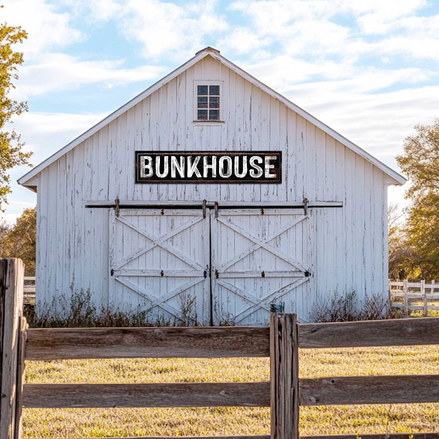 bunkhouse farmhouse sign on a white barn with white lettering.