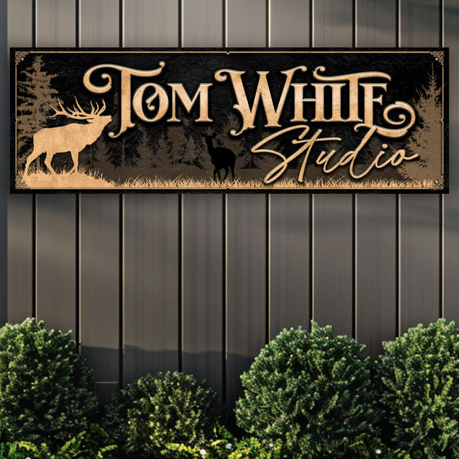 decorative signs on a black wall, the sign has gold letters on black textured background