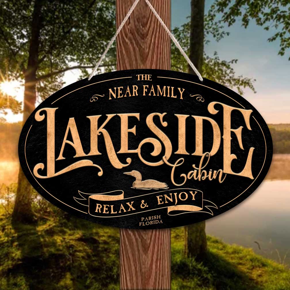 Lake house decor sign on a metal oval black textured sign with the words Lakeside Cabin relax and enjoy..