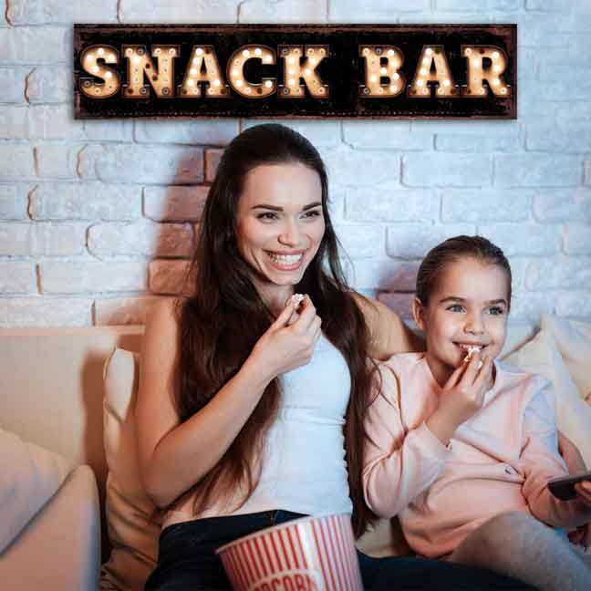 Theater room decor snack bar sign on black distressed background with the words Snack Bar in faux marquee lights