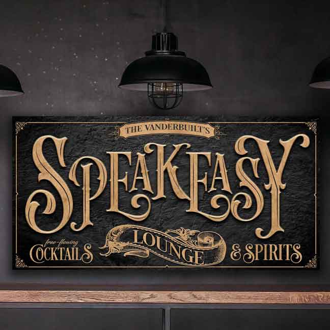 Speakeasy decor art in gold letters on black stone with ornate border and the words: Speakeasy Lounge-free flowing cocktails and spirits.