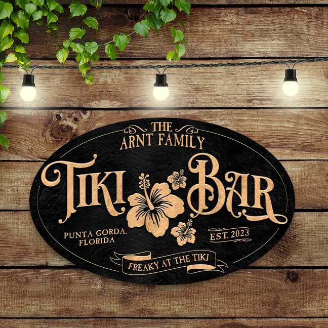 Tiki Bar Sign with gold letters on a black textured oval background with family name.