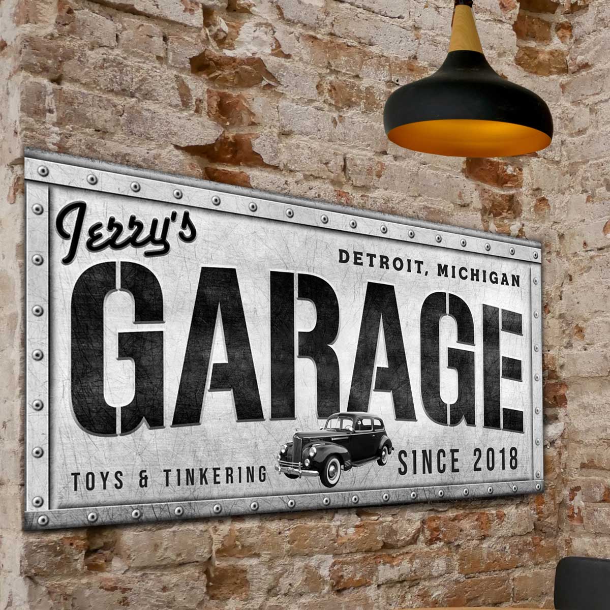 garage sign made of metal with rivets and the words, Jerry garage, city and state, toys and tinkering, with est. date.
