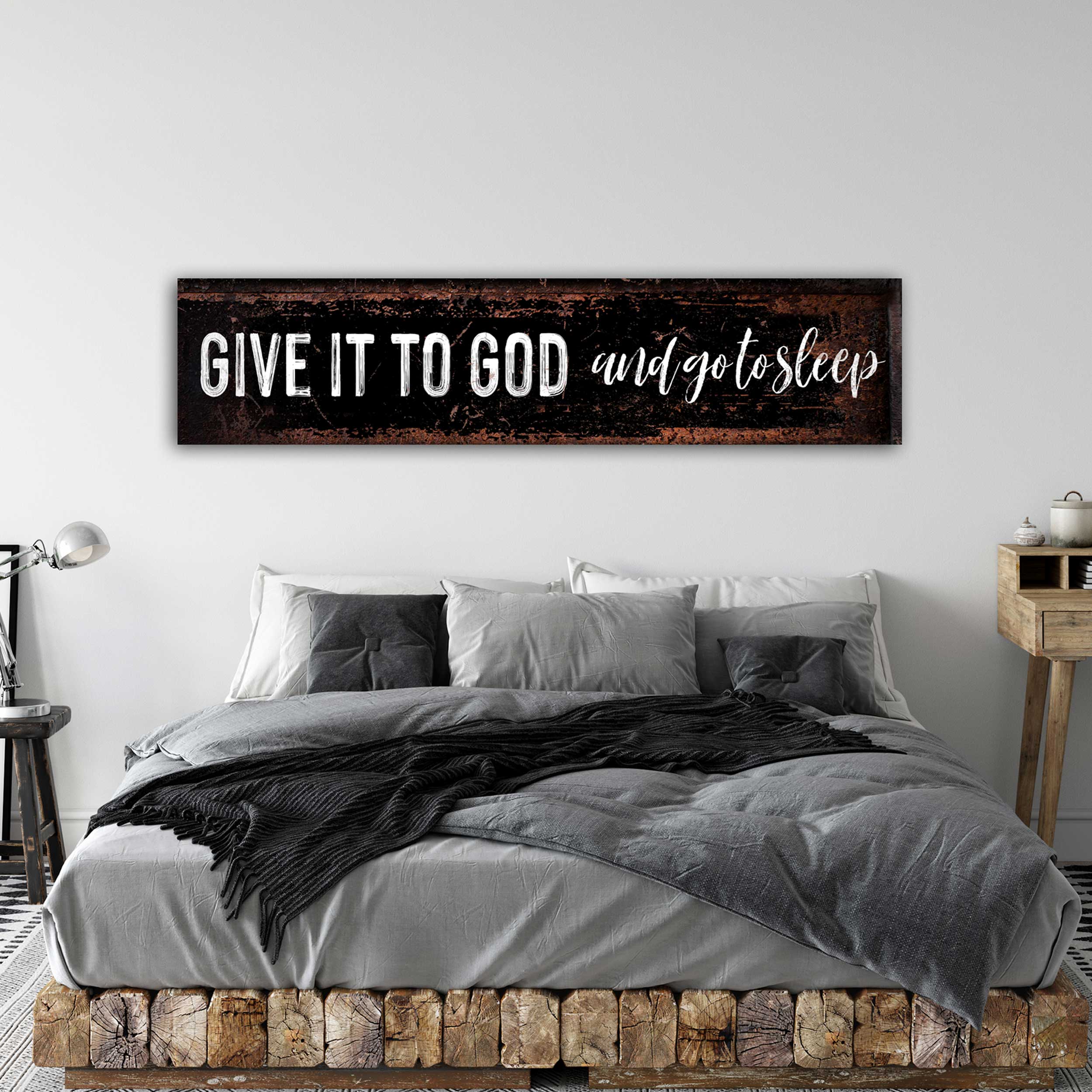 Give it to God and go to sleep sign with white letters on distressed black canvas.