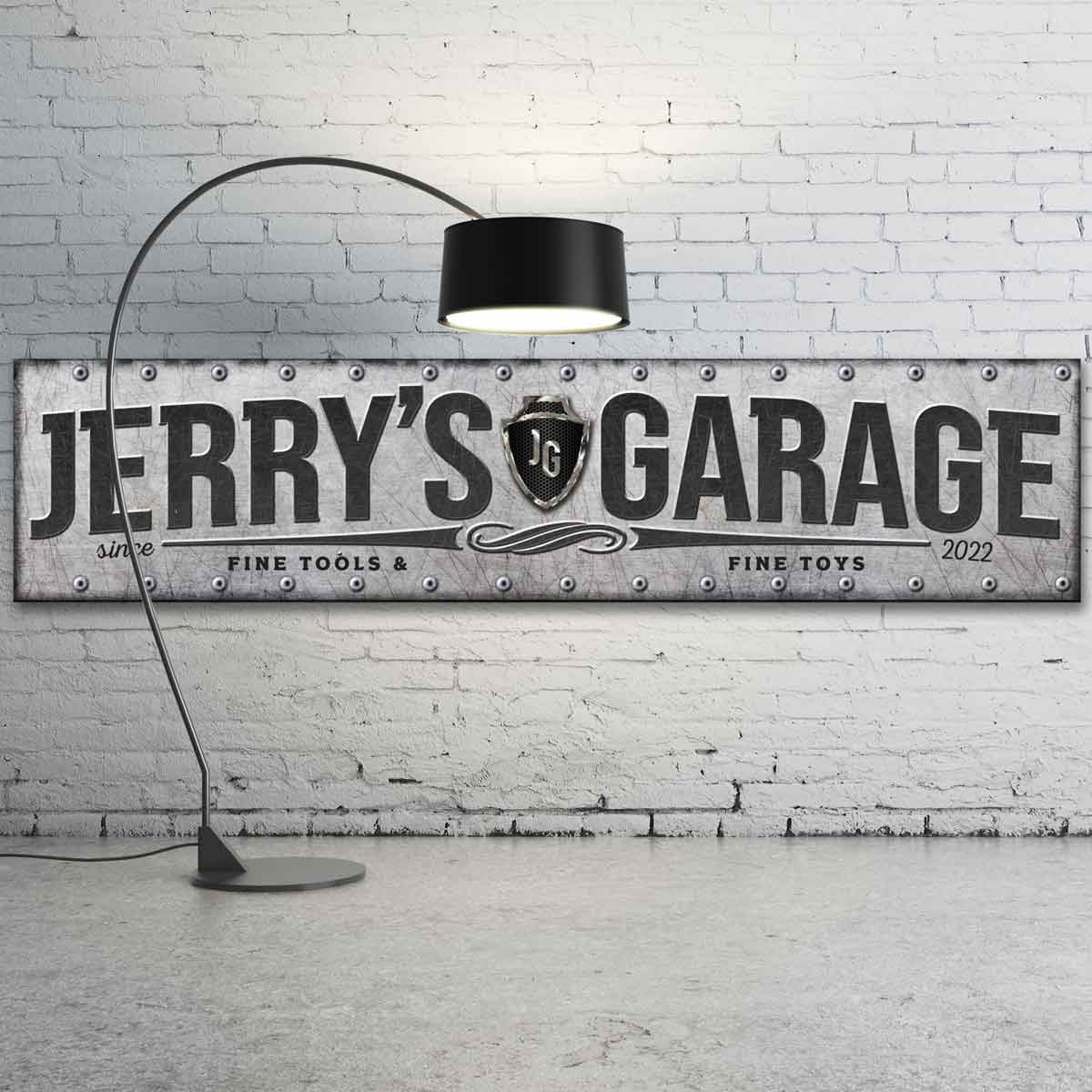 Industrial personalized garage sign. Large metal garage sign with personalized name and metal stamping around outer edge. Font is all caps and dark gray/ black. 