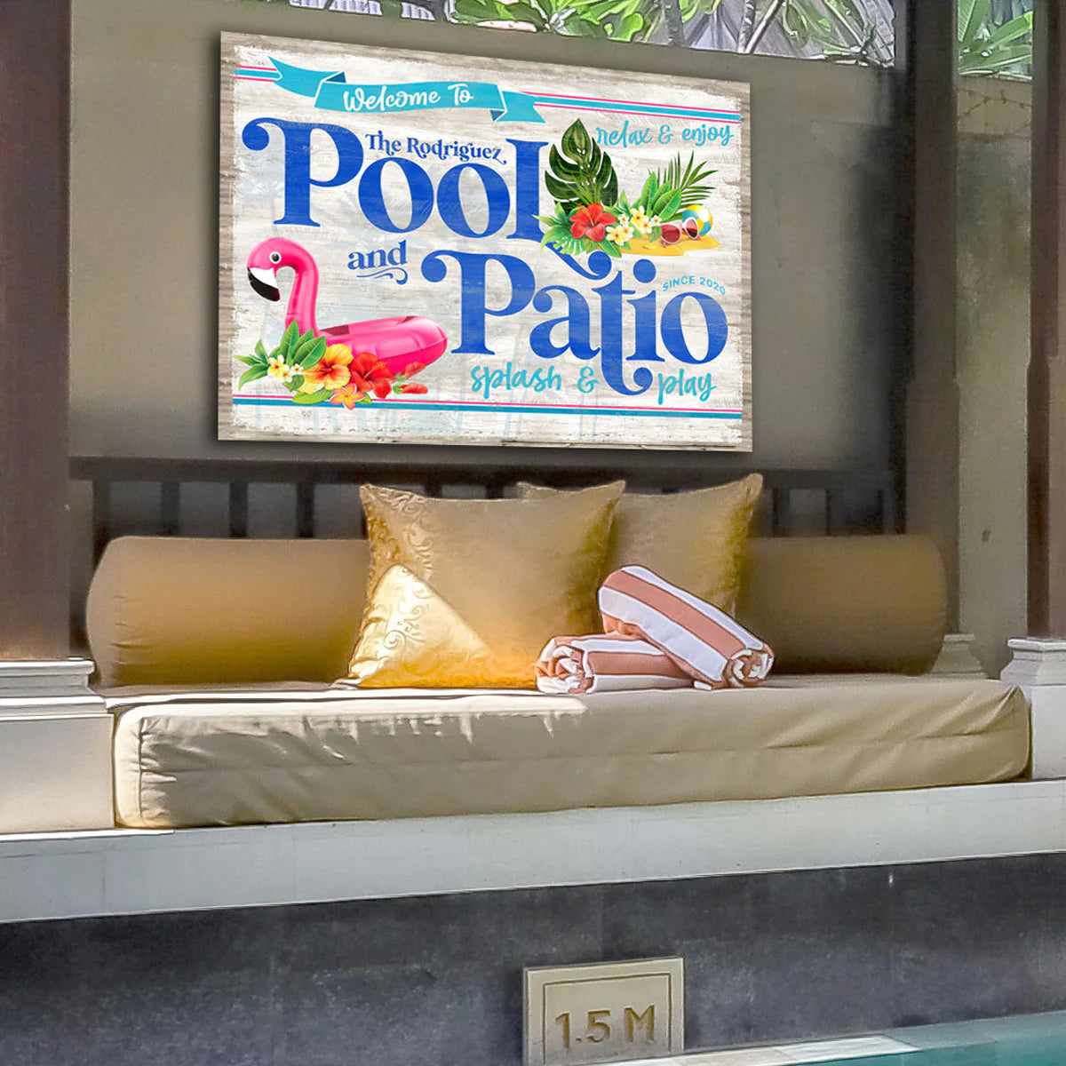 bright custom metal pool and patio sign on white faux wood. Hot pink Flamingo pool float and tropical foliage. 