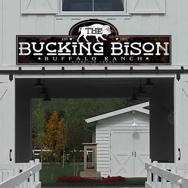 Large metal barn sign The bucking bison on rustic black background with a buffalo and the words Bucking Bison Ranch Sign