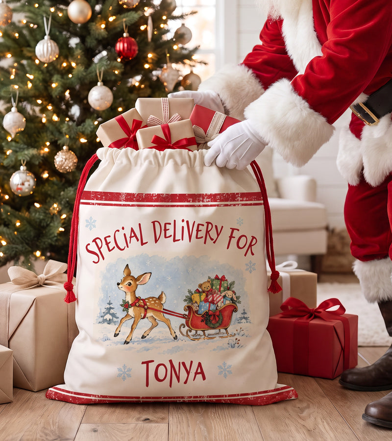 Personalized baby Santa sack with a watercolour fawn pulling a sleigh of toys, being filled with Christmas gifts