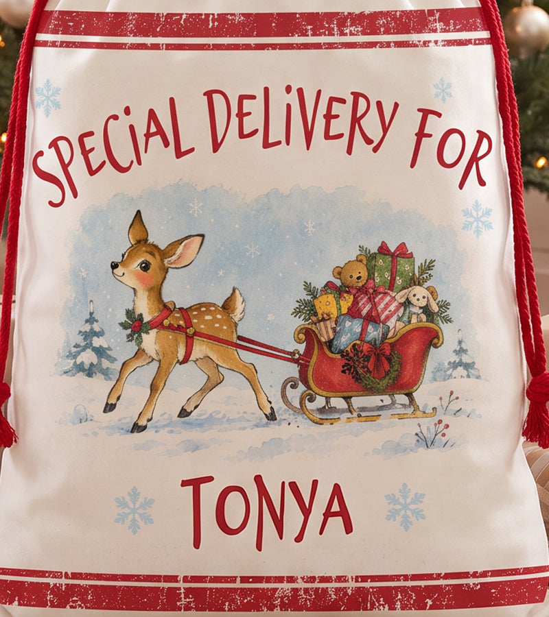 Close up of the watercolour baby reindeer artwork on a personalized Santa sack, showing the fawn in a holly collar pulling a red sleigh loaded with toys