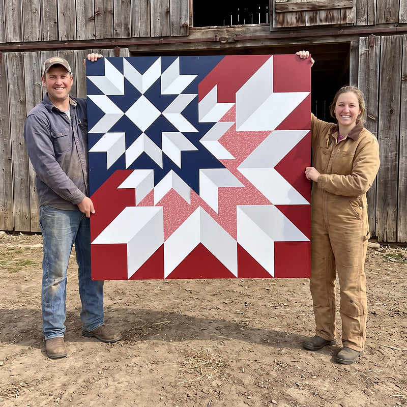 Two people holding a large red, white and blue barn quilt between them, showing the scale of the 48 inch size