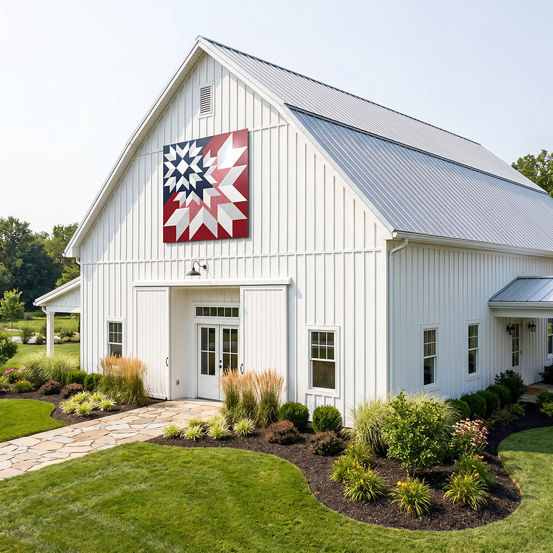 Barn quilt sign on the gable of a white modern farmhouse barn with a standing seam metal roof