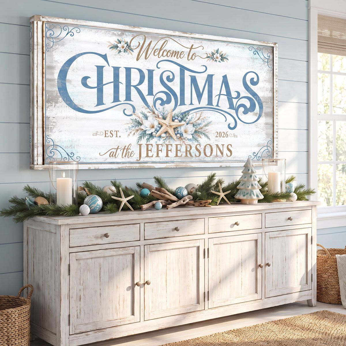 Family name beach Christmas sign above a whitewashed sideboard with garland, candles and starfish