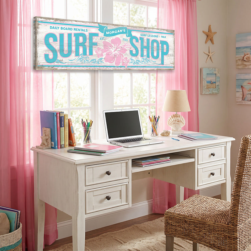 Beach wall decor sign above a white study desk in a girls bedroom with pink curtains