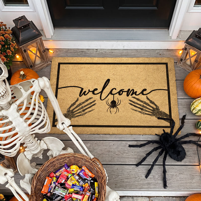 Bones welcome mat with skeleton hands on a porch with a skeleton, candy basket and pumpkins