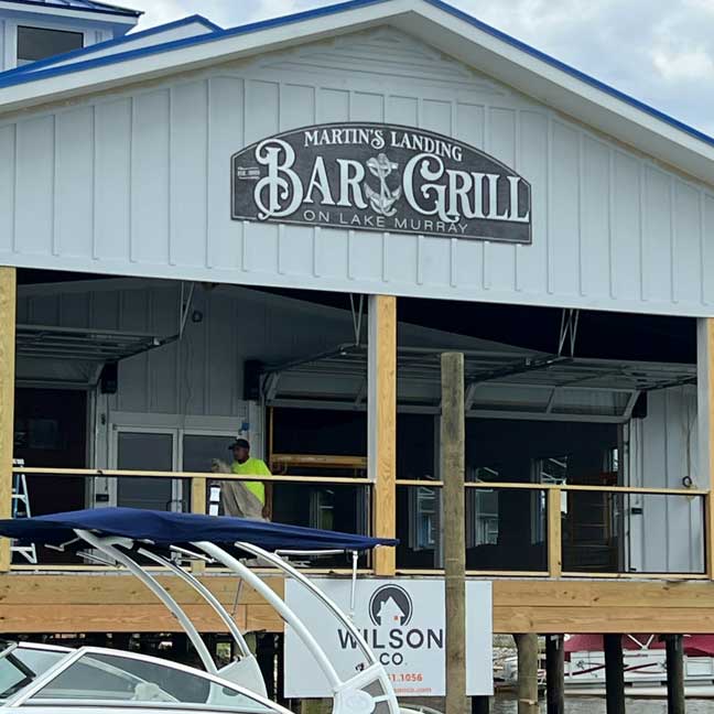 business signs for bar and grill, black with silver lettering on Marina building