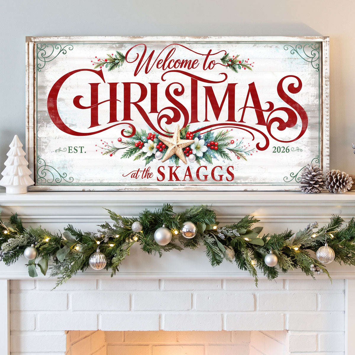 Personalized Christmas sign above a white brick fireplace with a lit garland and silver ornaments