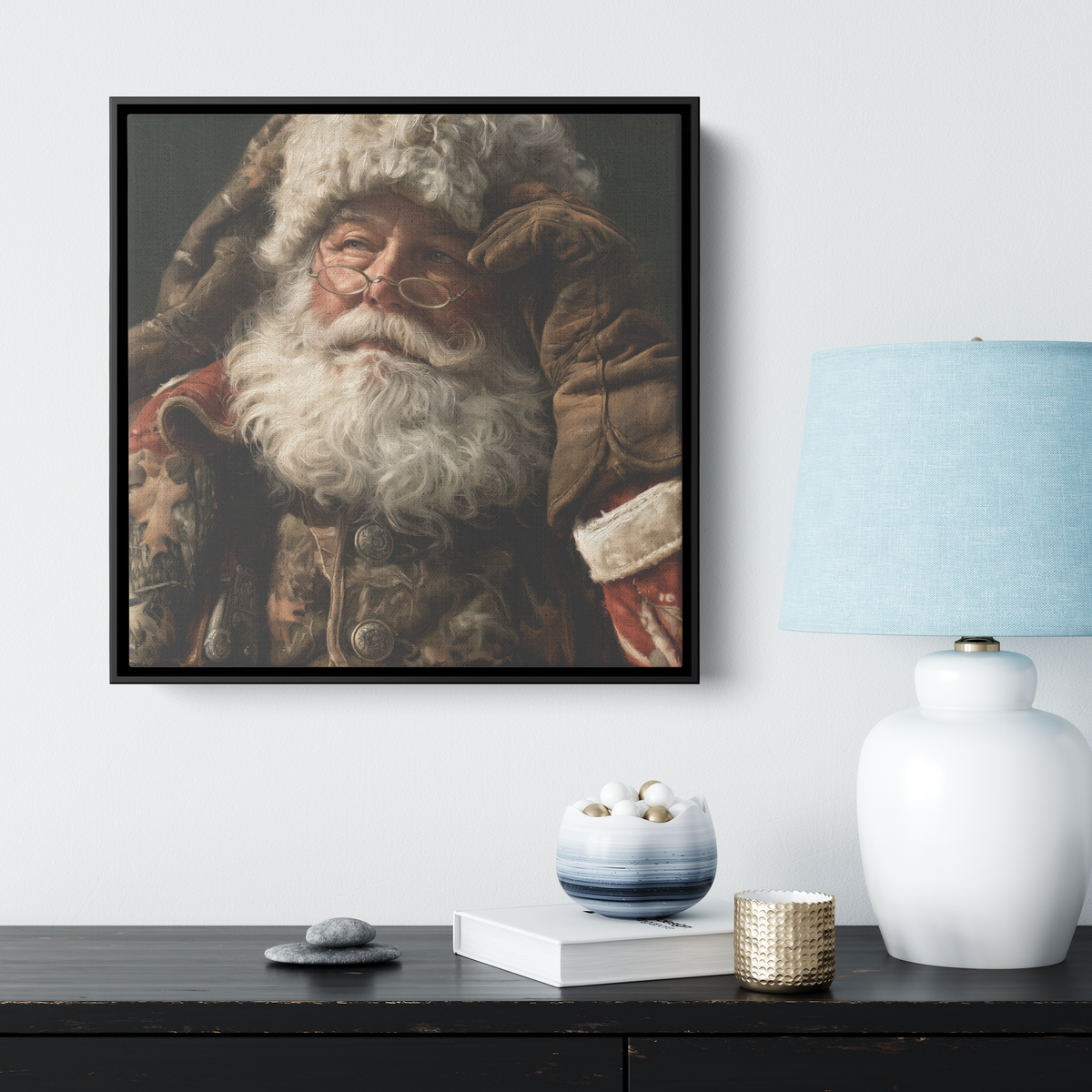 Rustic hunting Santa canvas in a black frame above a dark sideboard with a lamp and books