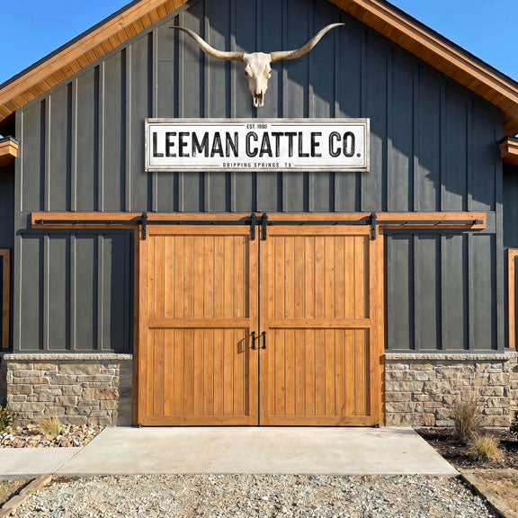 Barn with wooden doors and a cattle ranch sign for Leeman Cattle 