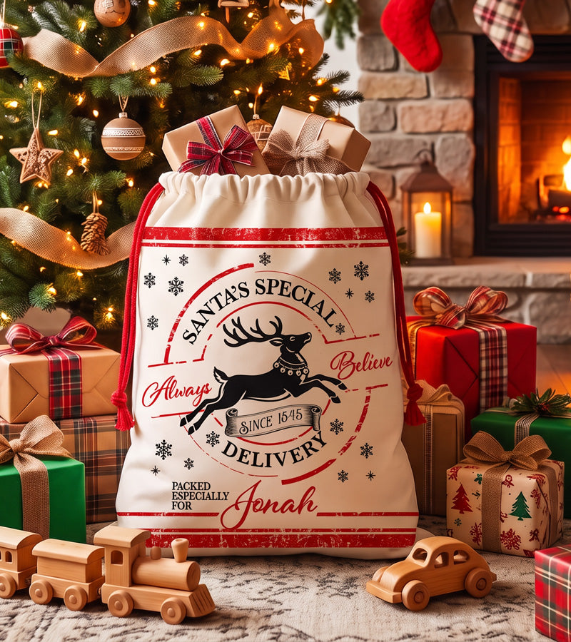 Christmas gift bag personalized with a name, Always Believe reindeer design, beside a lit fireplace