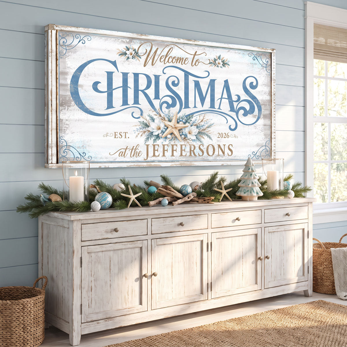 Coastal Christmas welcome sign above a sideboard with pine garland, candles, starfish and small trees