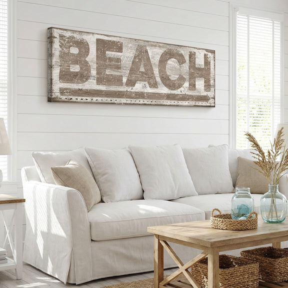Living room with a 'BEACH' sign on the wall above a white sofa.