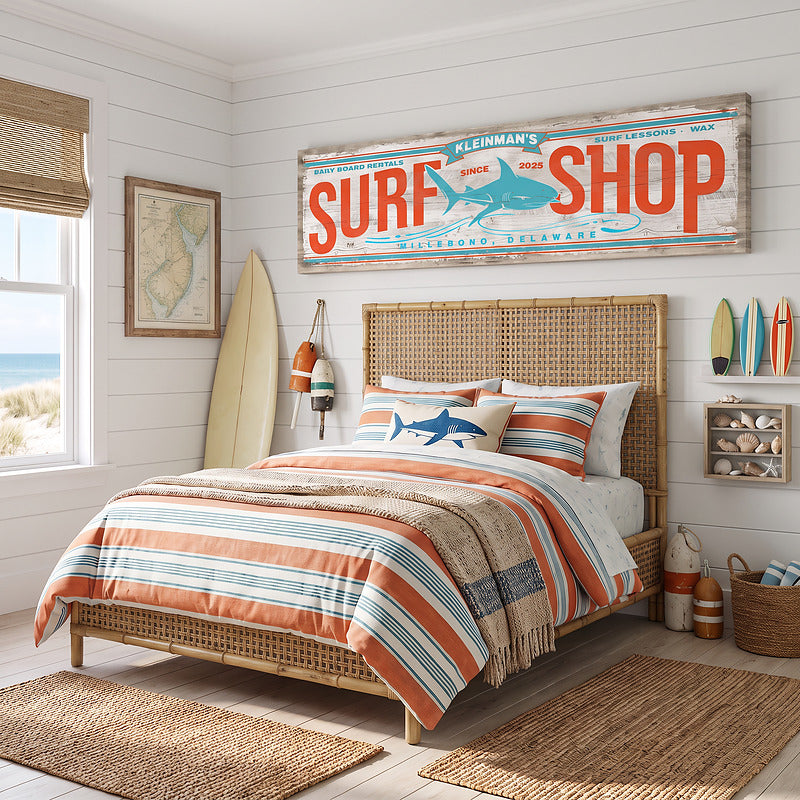 Coastal wall art surf decor sign above a rattan headboard in a bright beach house bedroom