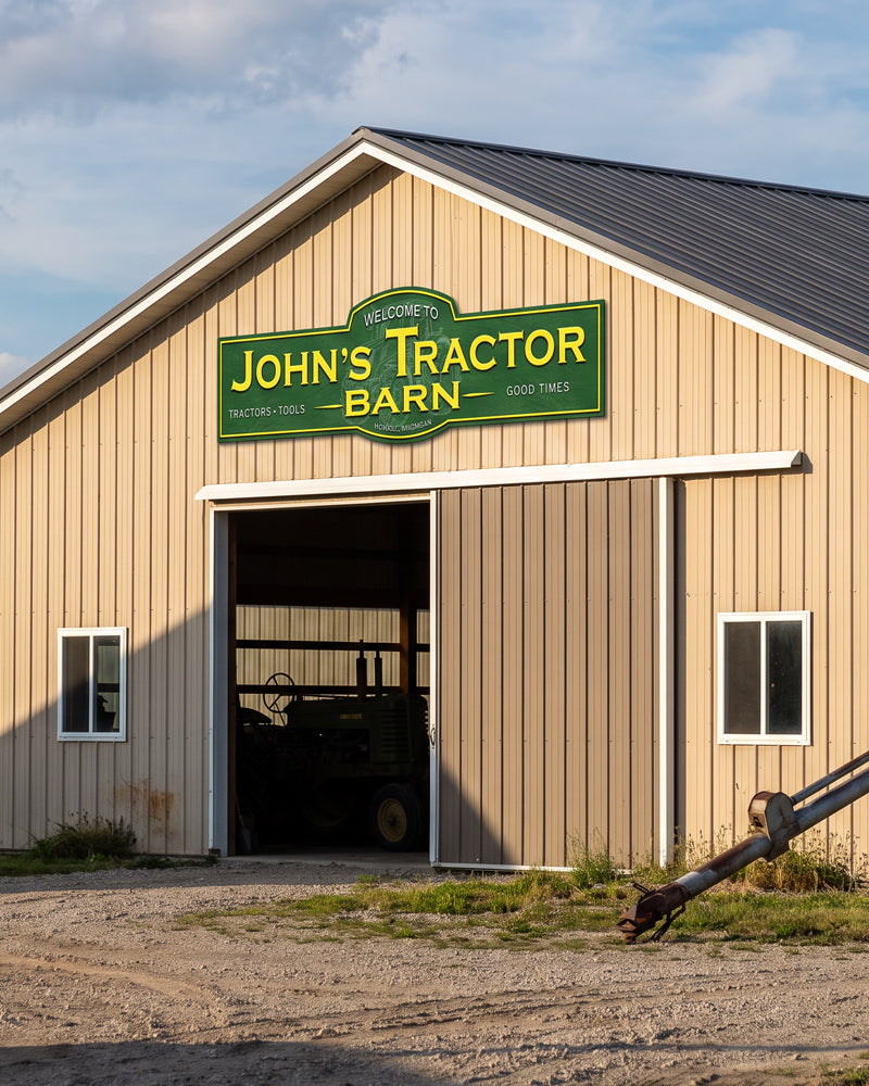 Custom barn sign with a family name in green and yellow on a tan farm pole barn exterior