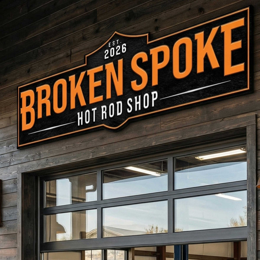 custom business sign on the front of a business building, above a glass garage door named broken Spoke