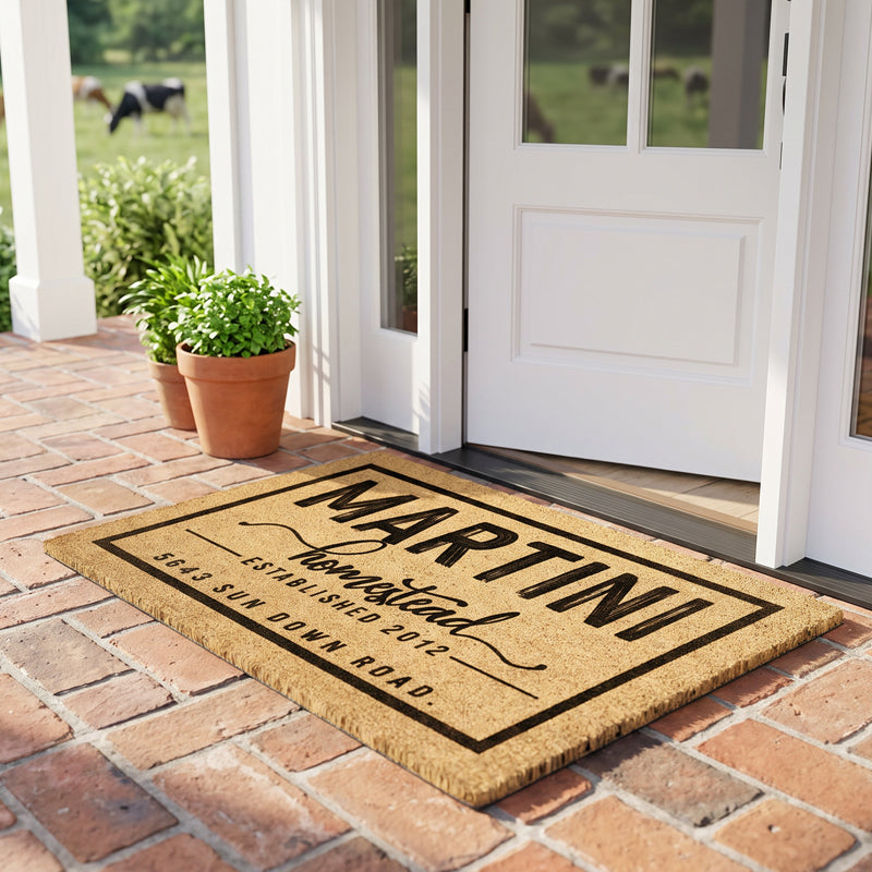 Custom coir welcome mat with name and address on a brick porch with cattle grazing beyond