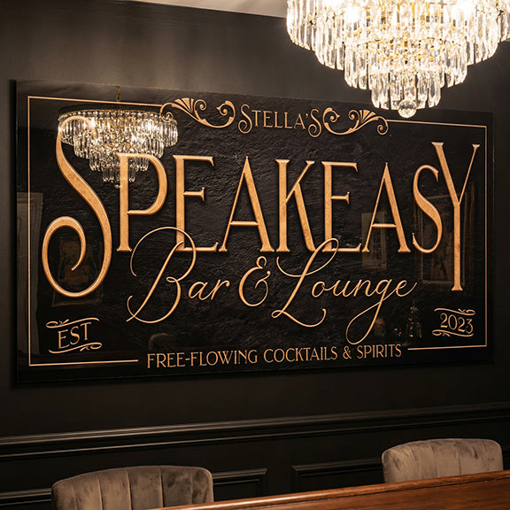 Decorative sign for 'Stella's Speakeasy Bar & Lounge' with gold text on a dark background, featuring chandeliers on acrylic material