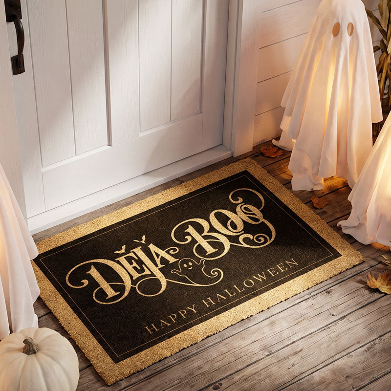 Deja Boo Halloween welcome mat in gold on black at a white door with a lit ghost and pumpkin