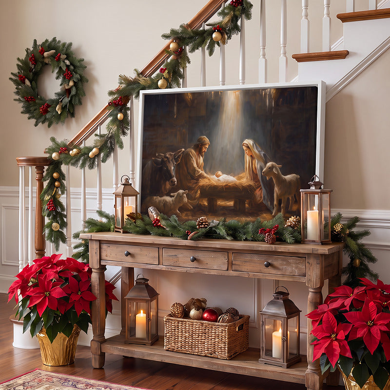 Nativity canvas in a white frame on a rustic console in an entryway with lanterns, garland and red poinsettias