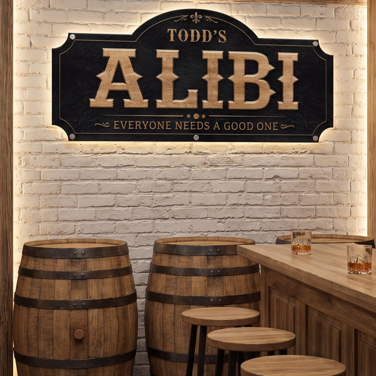 Personalized funny bar sign reading Todd's Alibi Everyone Needs A Good One, LED backlit on a white brick home bar wall with whiskey barrels