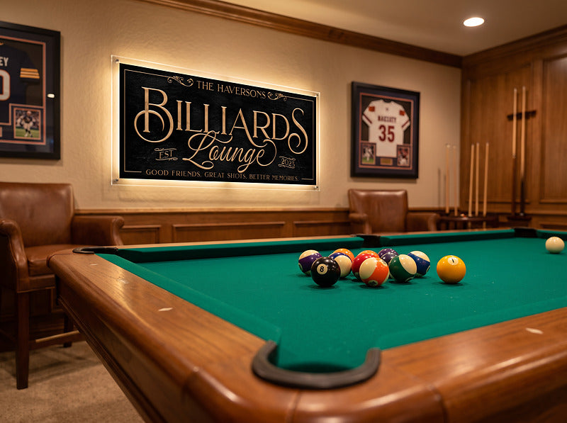 Game room billiards sign on a wood panelled wall above a pool table, with leather seating and framed memorabilia