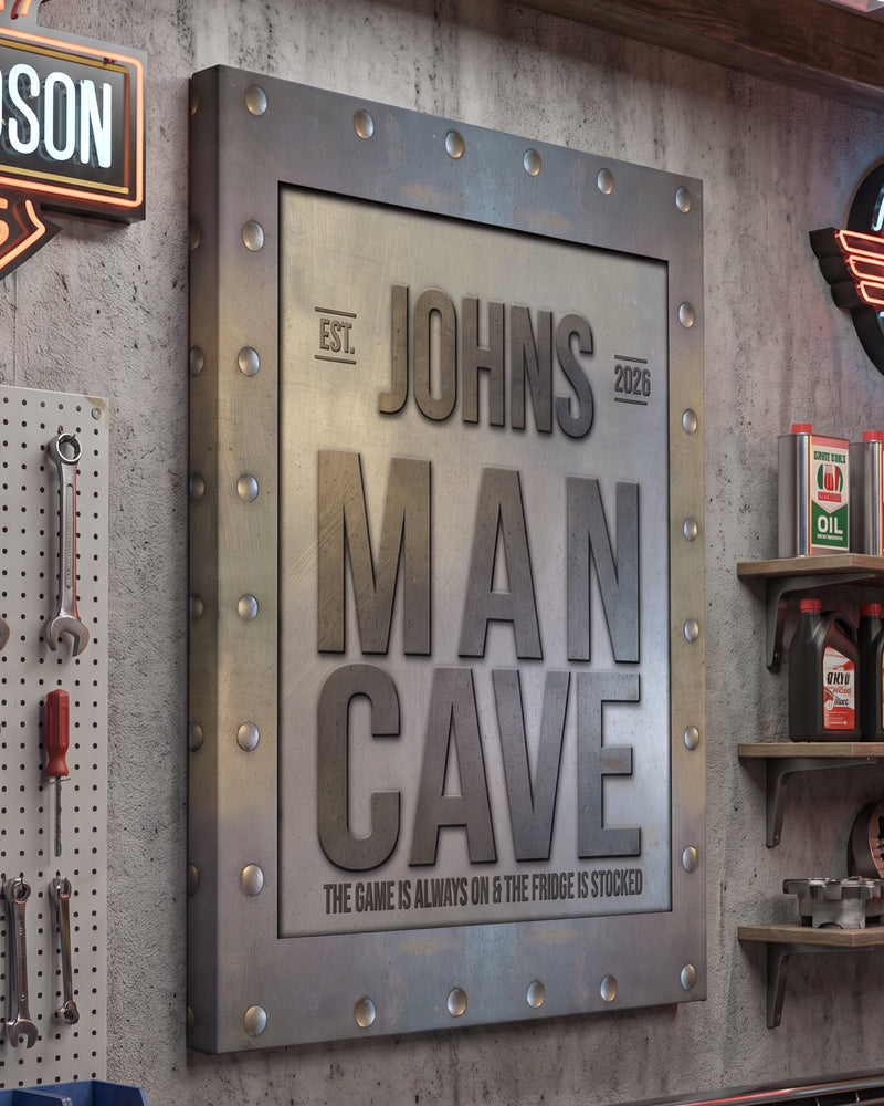 Garage man cave sign on a concrete wall between a pegboard of wrenches and shelves of oil cans
