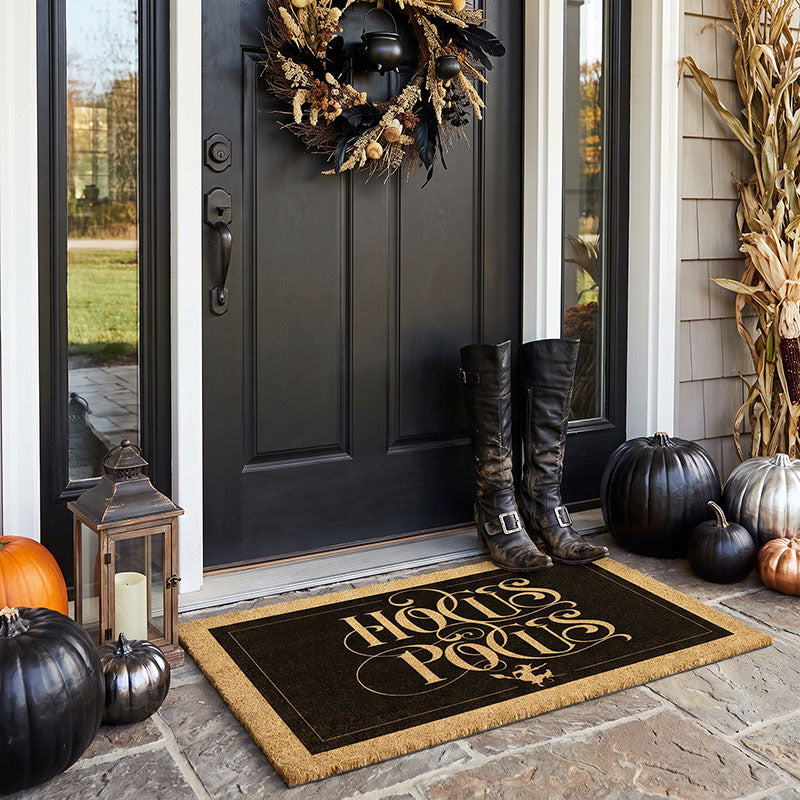 Hocus Pocus witch doormat at dark front door with Halloween wreath witch boots and black pumpkins