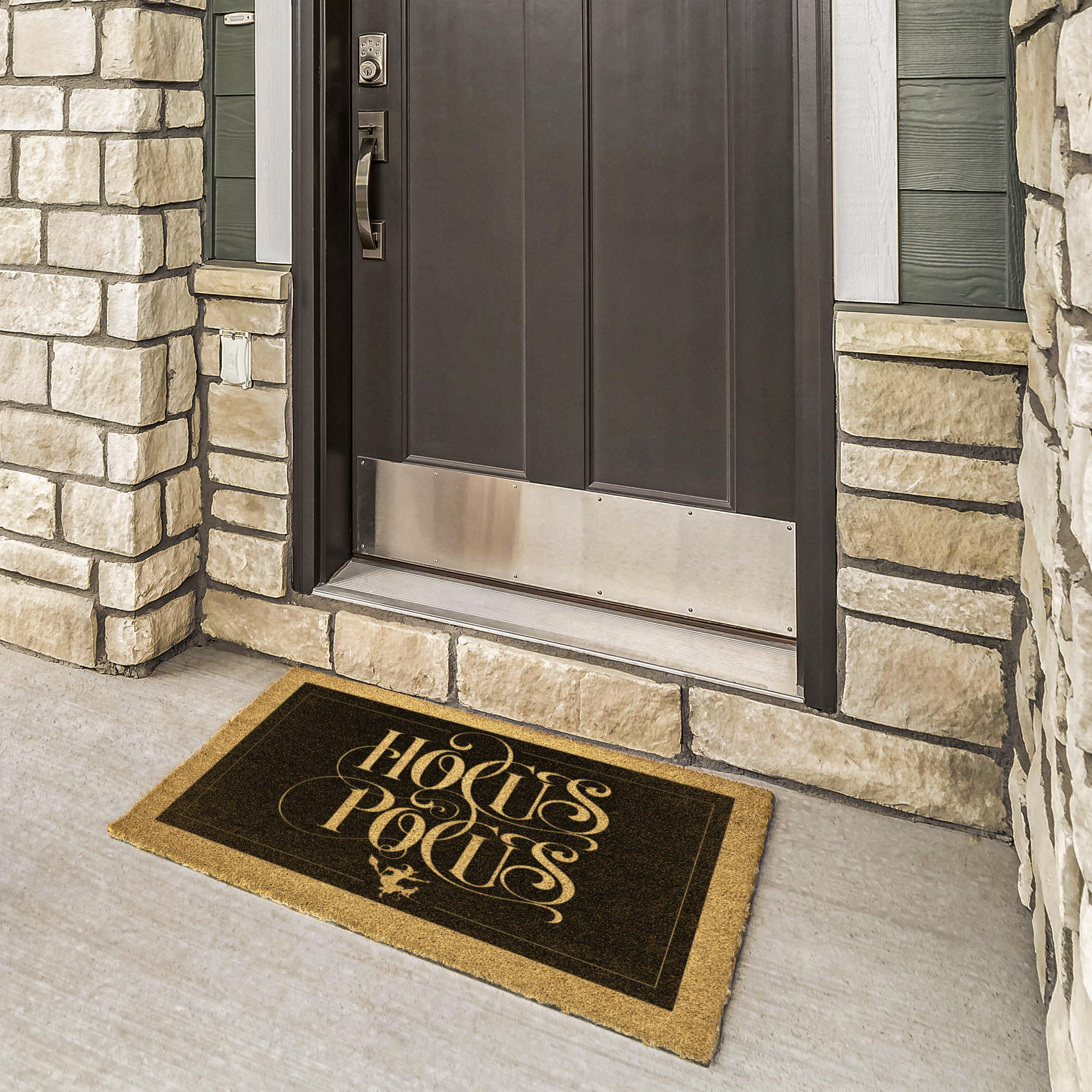 Hocus Pocus doormat in gold on black coir at a bronze front door framed by cream stone