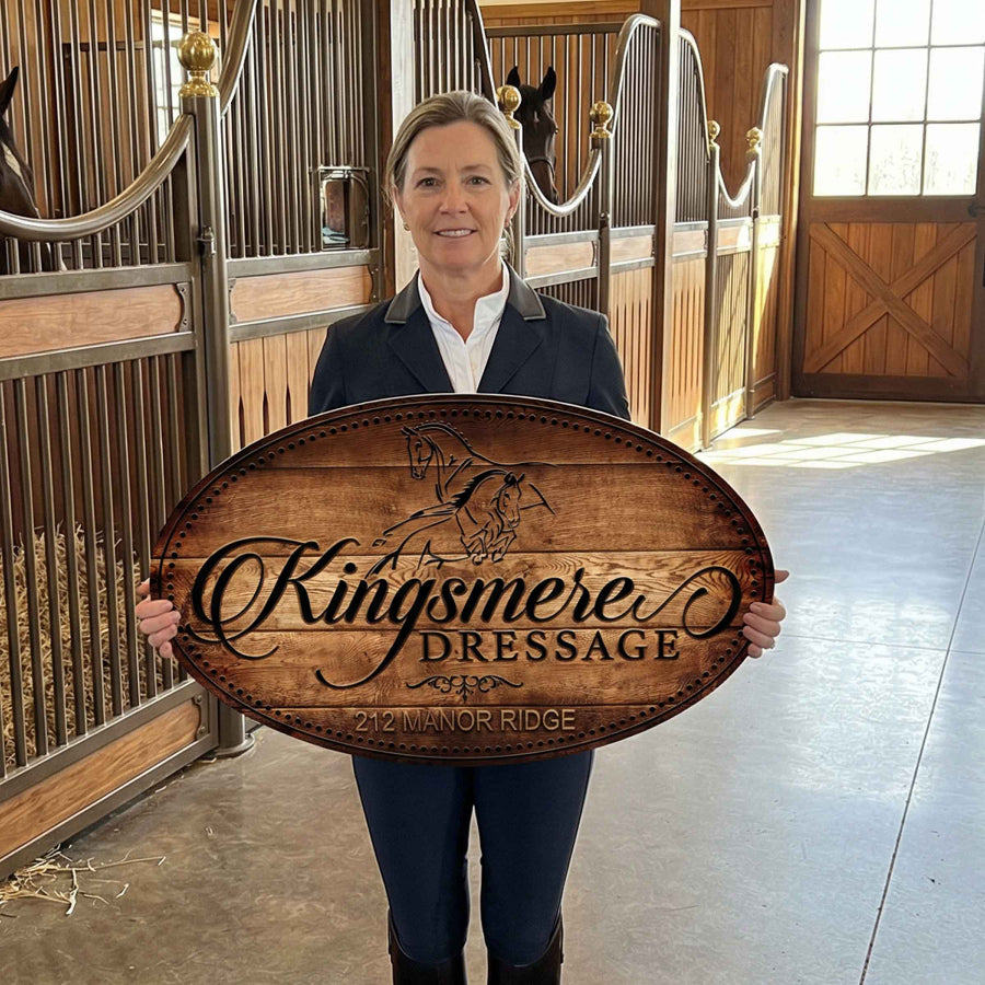 woman holding her stable sign in the hall of the barn