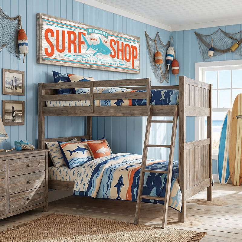 Kids surf decor sign above bunk beds in a boys coastal bedroom, personalized with a surf shop name and town