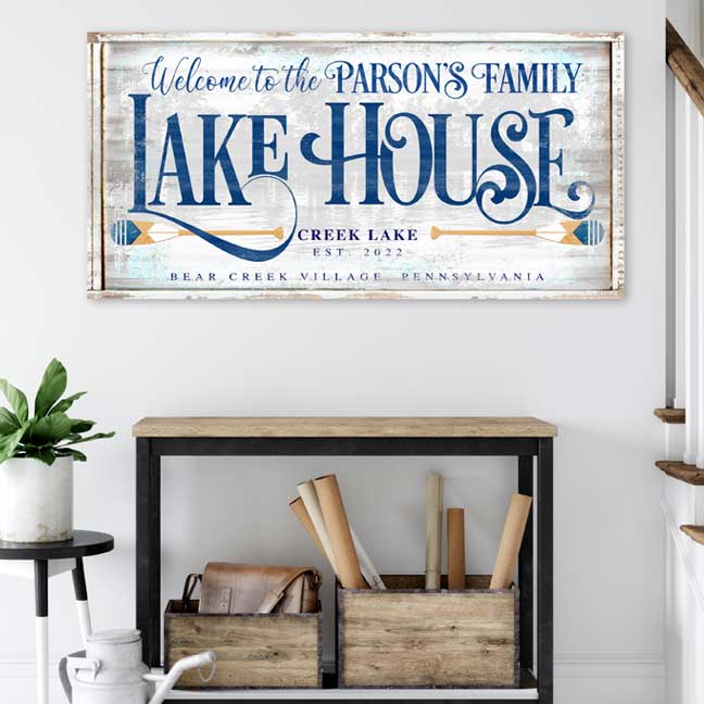 Lake house sign personalized on old distressed wood with blue lettering with the words Welcome to the lake house and lake name.