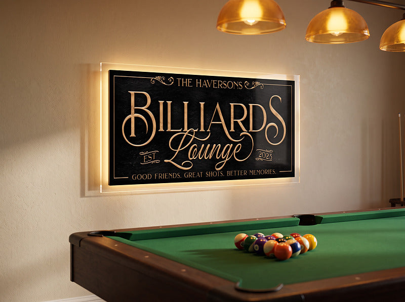 Man cave billiards sign under gold pendant lights above a pool table with racked balls
