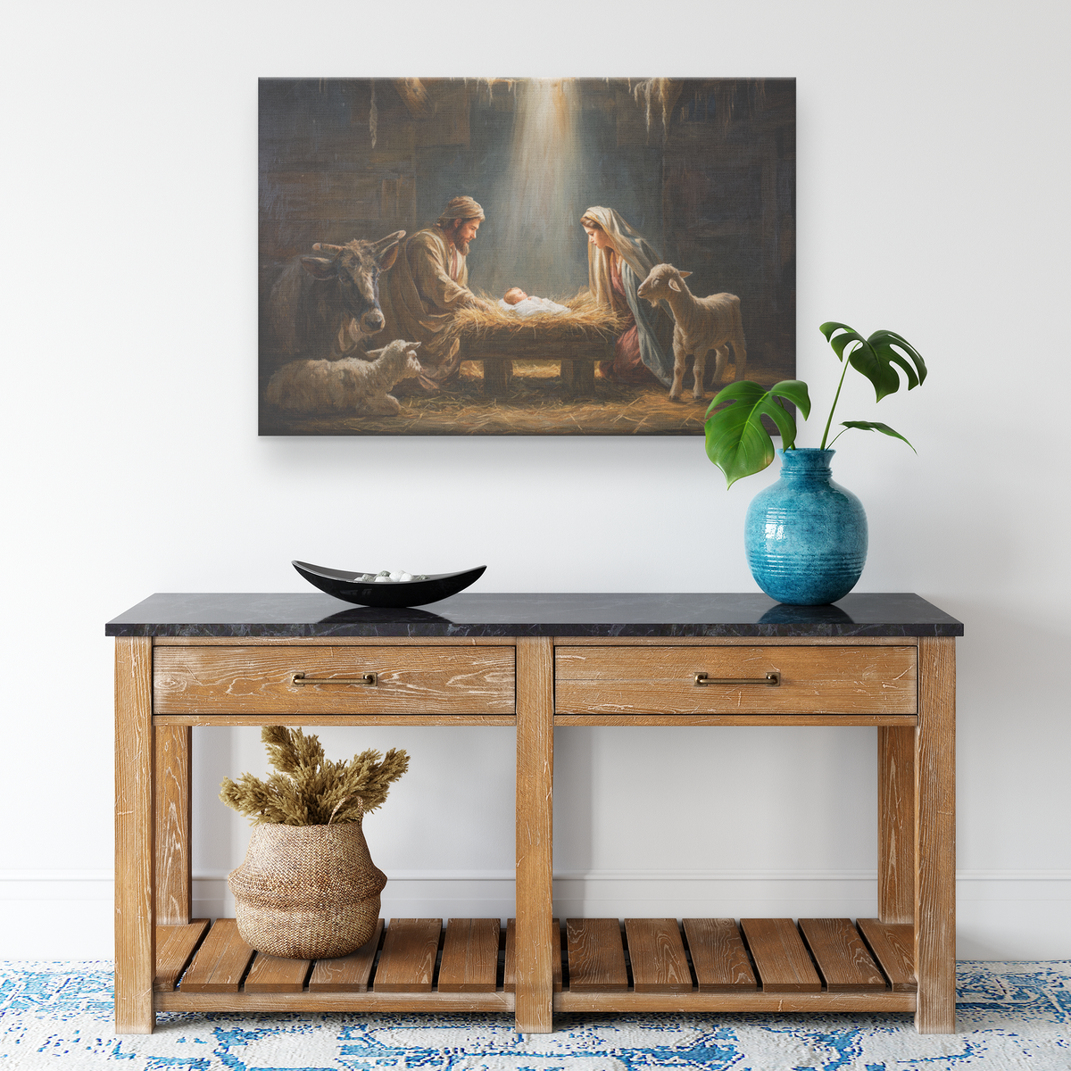 Nativity wall art canvas above a light oak console with a blue vase and monstera in a bright white entry
