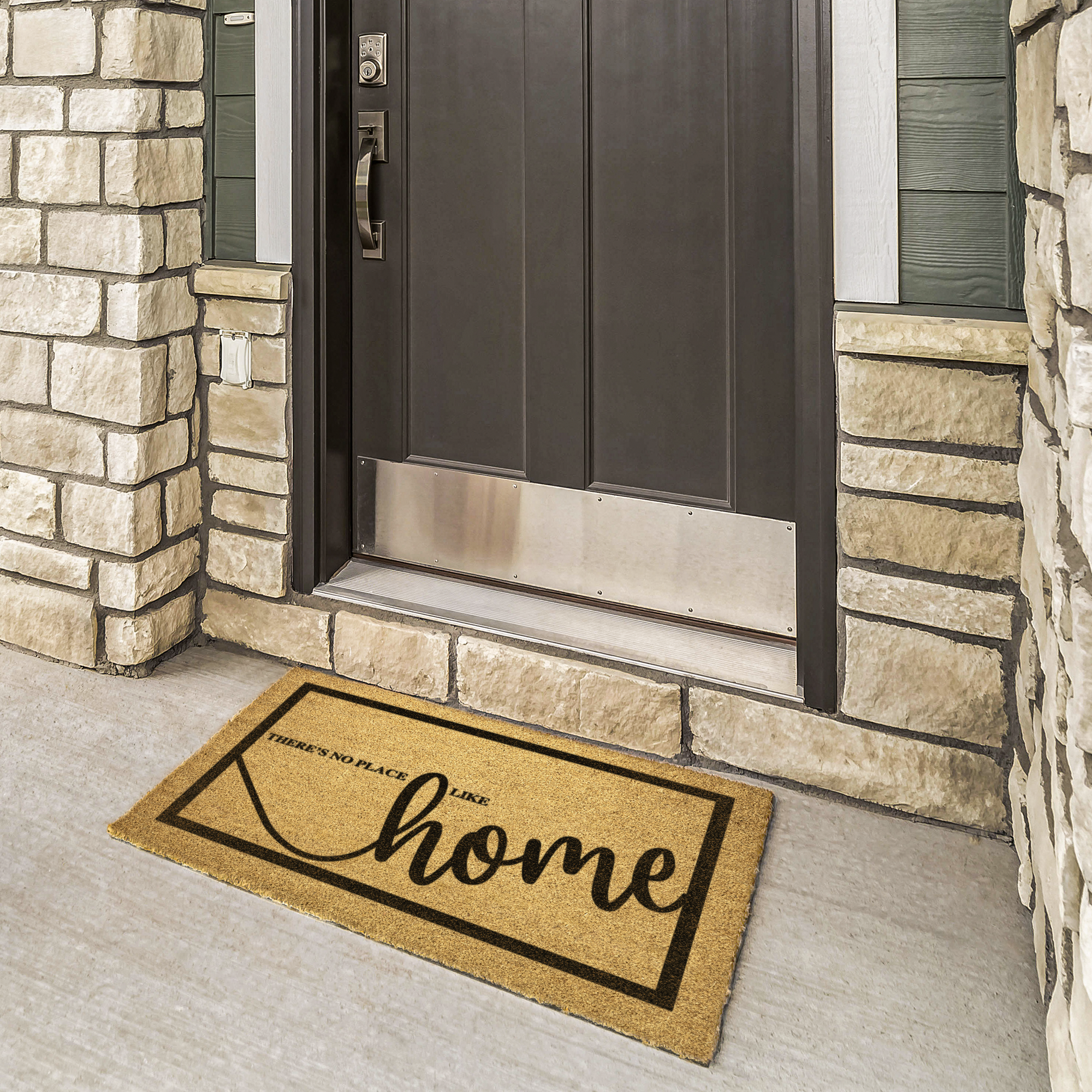 No Place Like Home doormat at a bronze door framed by cream stone