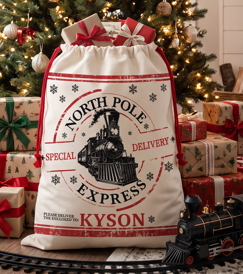 Personalized Santa sack printed with a vintage North Pole Express steam train postmark, standing under a decorated Christmas tree