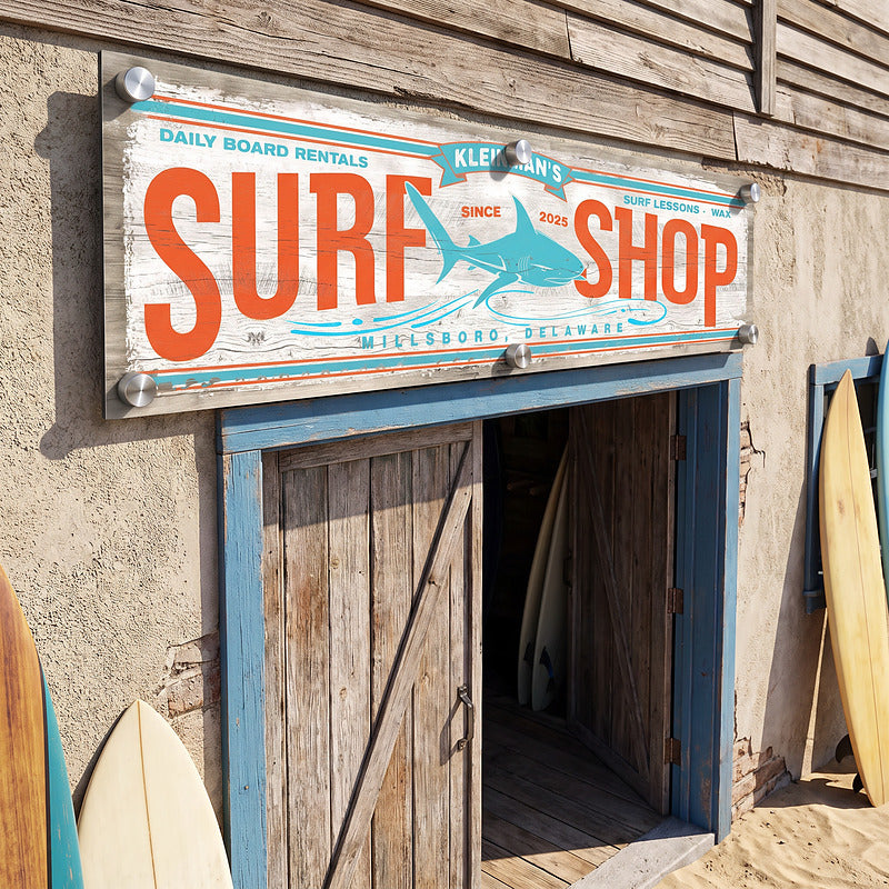 Outdoor beach decor surf sign fixed above a blue barn door on a weathered seaside shack