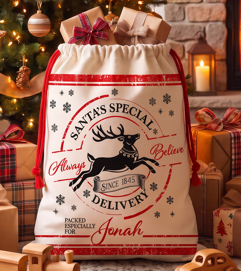 Personalized Christmas gift bag with a Santa's Special Delivery reindeer stamp and a name in red script