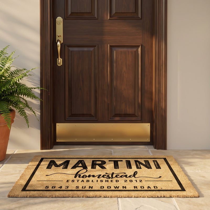 Personalized front door mat with family name, established year and street address, at a wood door